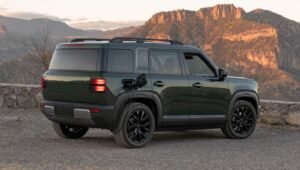 SUV híbrida mediana de diseño cuadrado color verde cargando en un mirador de carretera en México