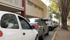 Fila de autos esperando afuera de una oficina de gobierno para el reemplacamiento en el Estado de México